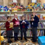 Students holding up goods for families