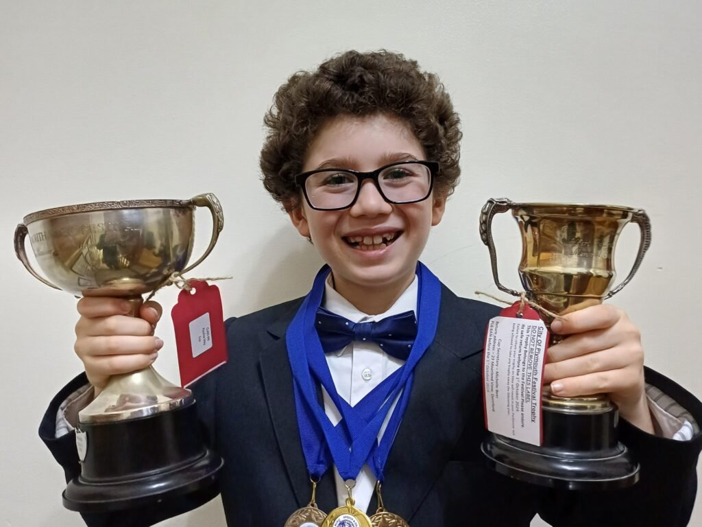 Student holding up trophies