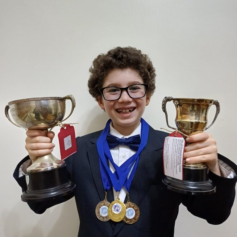 Student holding up trophies