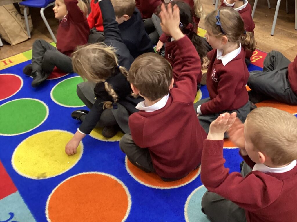 Students raising their hands in class