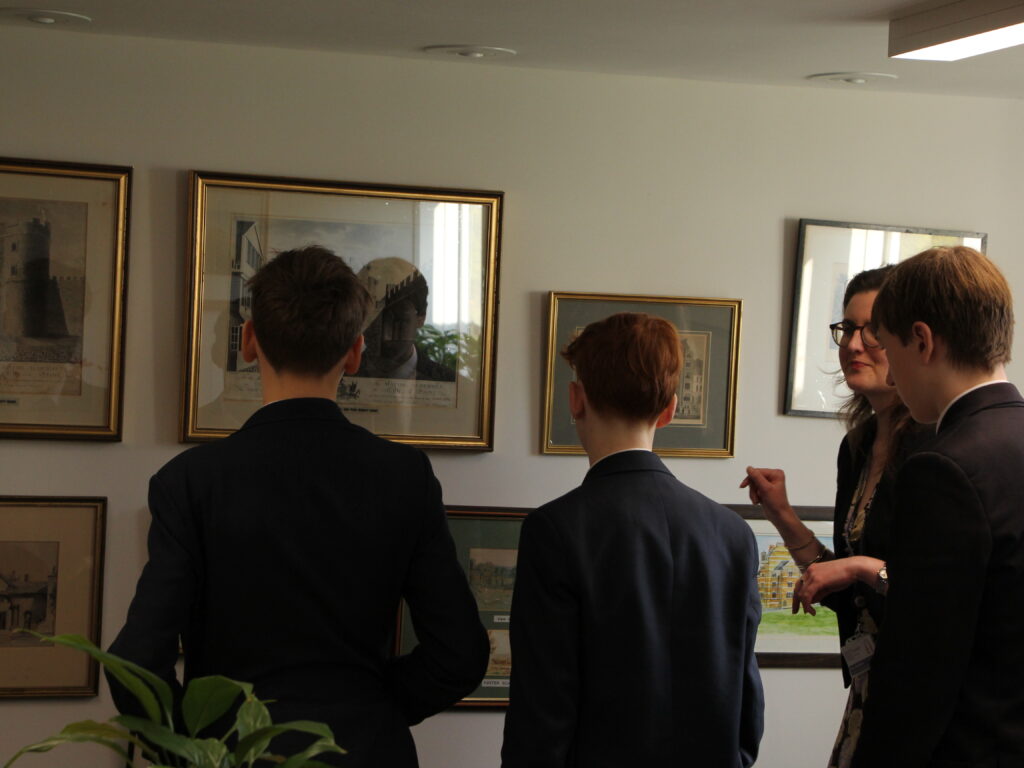 students looking at frames on a wall