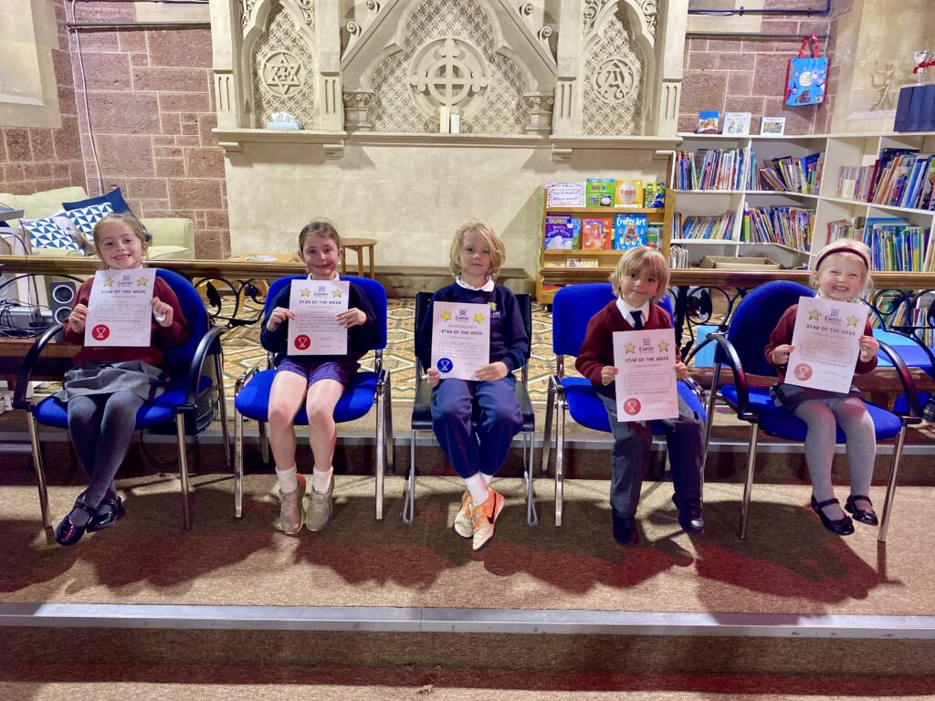 students showing their star of the week certificates