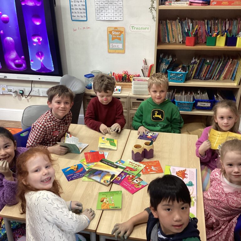 students sat around a table of books