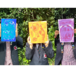 students holding up paintings