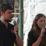 two people speaking into microphones