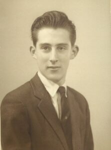 A black and white photo from circa 1970 of a head shot of a young man in a suit