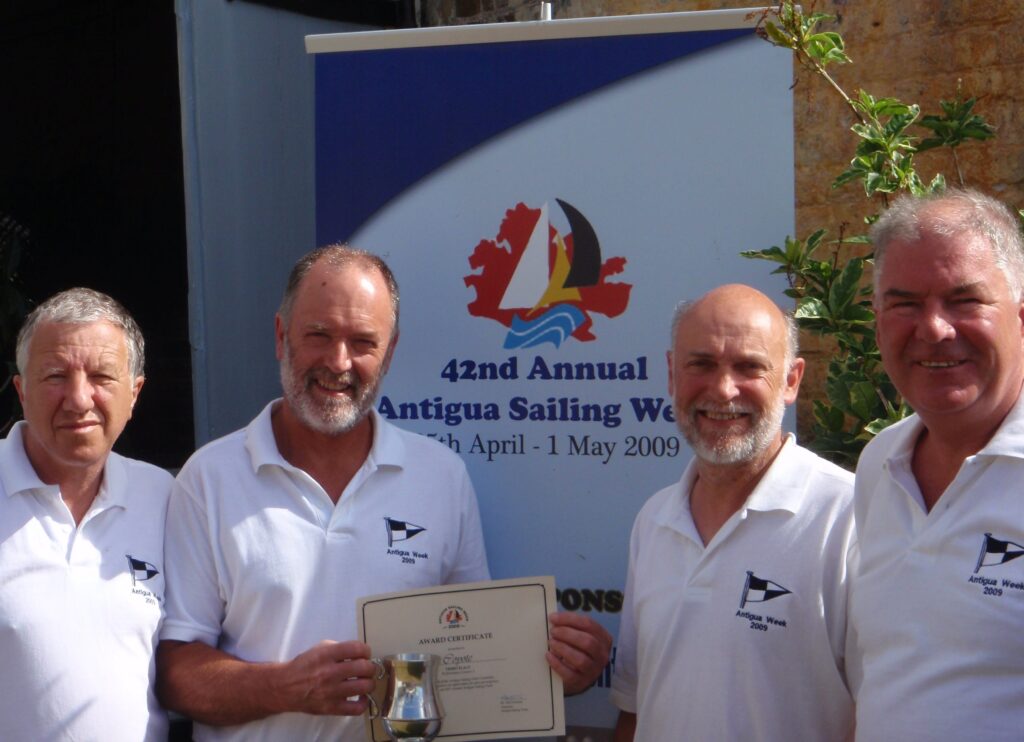 Four older gentlemen in a group photo with an award certificate and silver tankard