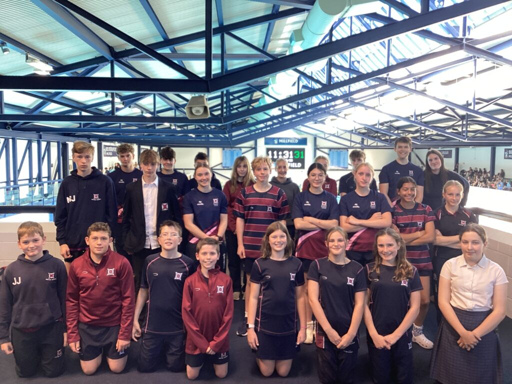 Group of 25 senior pupils in sports uniform on mezzanine of indoor pool