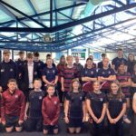 Group of 25 senior pupils in sports uniform on mezzanine of indoor pool