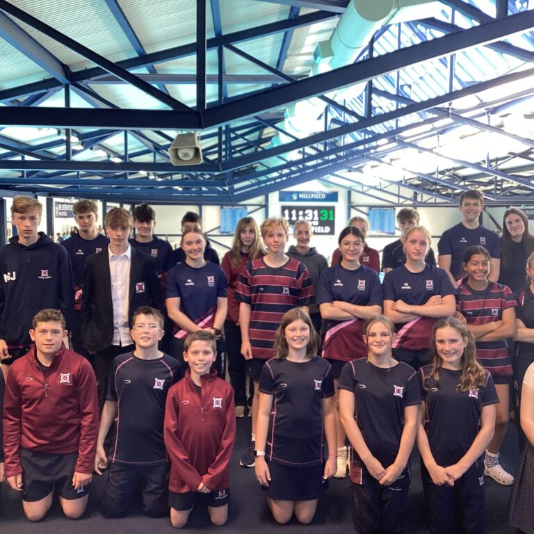 Group of 25 senior pupils in sports uniform on mezzanine of indoor pool