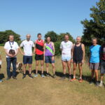 A group of runners in a field on a sunny day