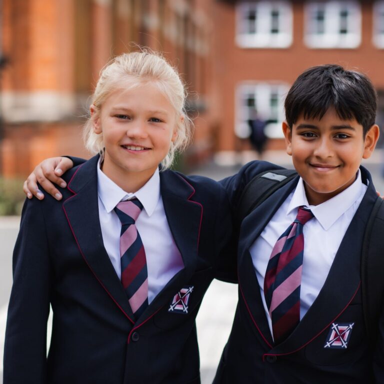 two boys in uniform outside with an arm around each other