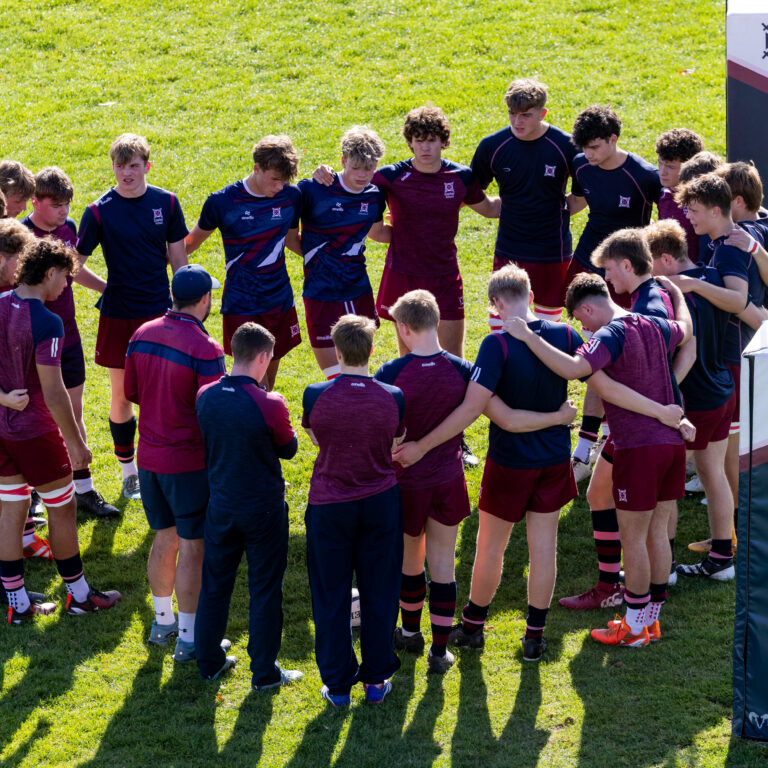Group of rugby players on field in circle with photo taken from above