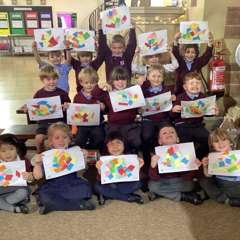 Reception pupils holding up snail drawings