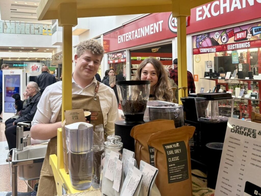 Two Exeter School students running a food and drink stall during a school enterprise market event.