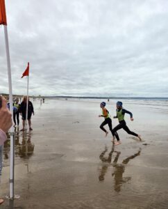 boys on the beach racing to the finish line.