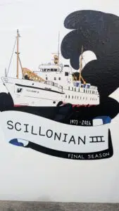 Illustrated ferry Scillonian III in white with orange cranes, against bold black smoke shapes, commemorating its final season (1977–2026).