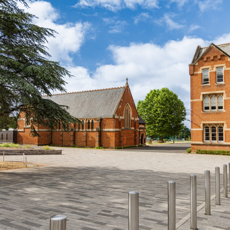 picture of red brick buildings along with trees and greenery surrounding