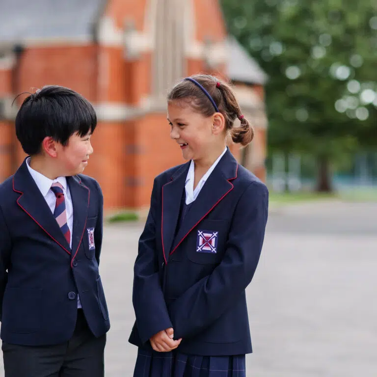 a little boy and girl laughing at each other whilst dressed smart