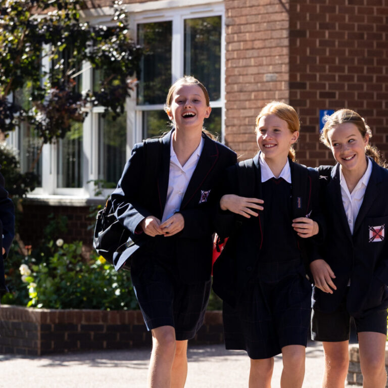 a group of girls walking in a line towards the camera smiling