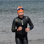boy in a wetsuit coming out the water