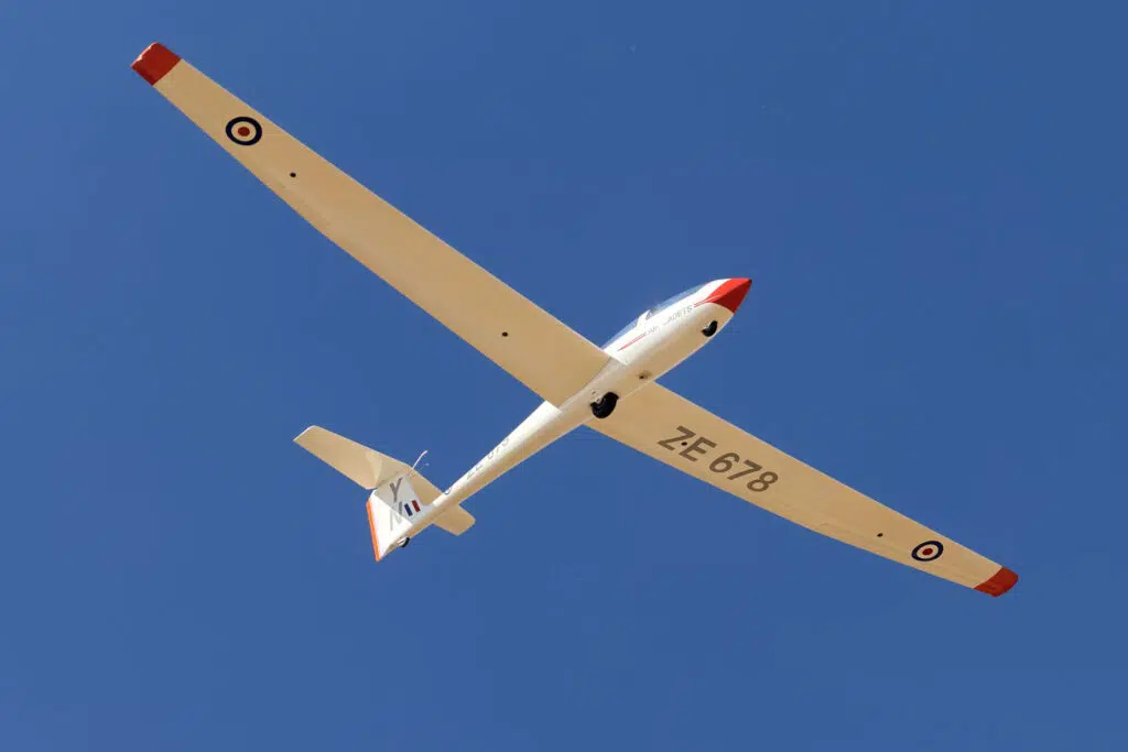 a plane up in the sky with a red tip and a red tip on a wings