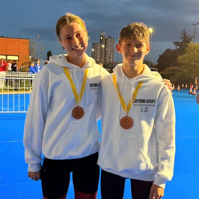 boy and a girl stood in white jumpers with a medal on
