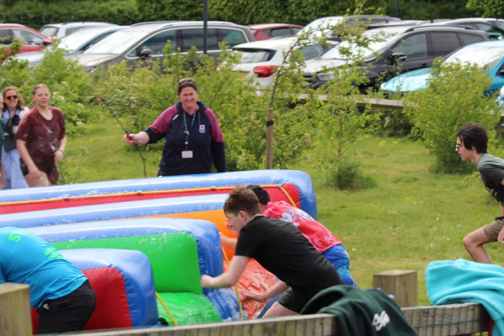 IMG 7866 – Exeter School Aoife-Jane helps out with the sixth form slip and slide inflatables fun day