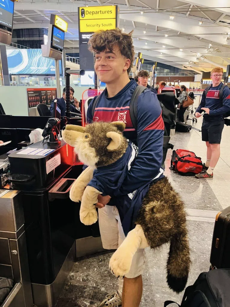 Screenshot 2026 10 23 At 110455 – Exeter School Rugby team at the airport with wolf teddy